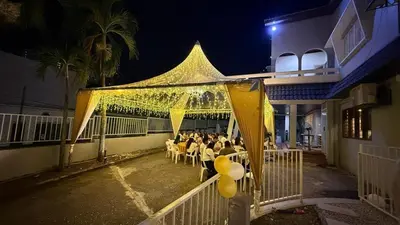 a group of people sitting at tables under a yellow tent at The Little Bali - 6Room - 18Pax in Kuala Lumpur