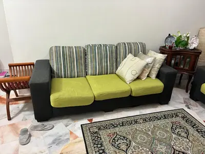 a black couch with green cushions in a living room at Baiduri Homestay in Kuala Lumpur