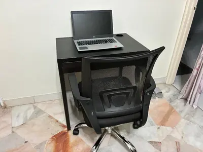 a black desk with a laptop and a chair at Baiduri Homestay in Kuala Lumpur