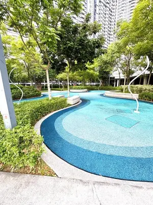 a blue swimming pool in a park with trees at M Vertica Homestay in Kuala Lumpur