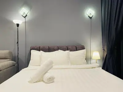 a bedroom with a bed with white sheets and pillows at The Majestic Gen Luxury Suites KLCC in Kuala Lumpur
