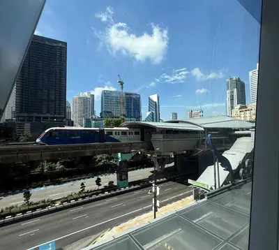 a train on a bridge over a highway in a city at Quill Residence - Blissful Urban Condo by Azmila in Kuala Lumpur