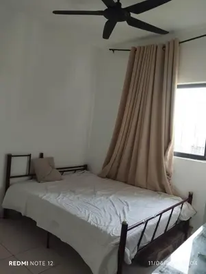 a bedroom with a bed with a ceiling fan at Flora Residency Setapak in Kuala Lumpur