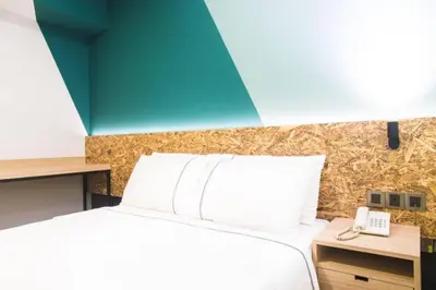 a bedroom with a bed and a desk with a phone at I LUX I-Hotel Kuala Lumpur in Kuala Lumpur