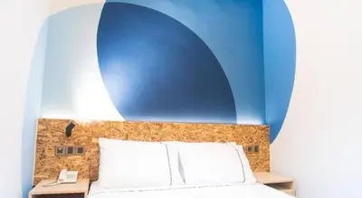 a bedroom with a bed with a blue wall at I LUX I-Hotel Kuala Lumpur in Kuala Lumpur