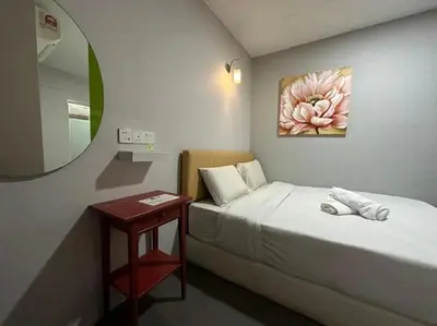 a small bedroom with a bed and a table at Triple B Hotel in Kuala Lumpur