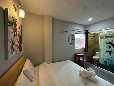 a bedroom with a bed and a bathroom with a shower at Triple B Hotel in Kuala Lumpur