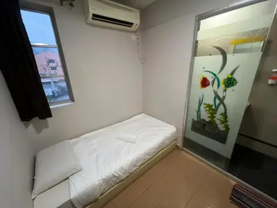a small room with a bed and a window at Triple B Hotel in Kuala Lumpur