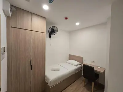 a bedroom with a bed and a desk with a chair at The Backpackers Hut Chow Kit in Kuala Lumpur