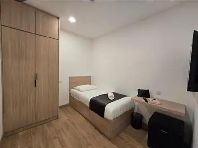 a small bedroom with a bed and a desk at The Backpackers Hut Chow Kit in Kuala Lumpur