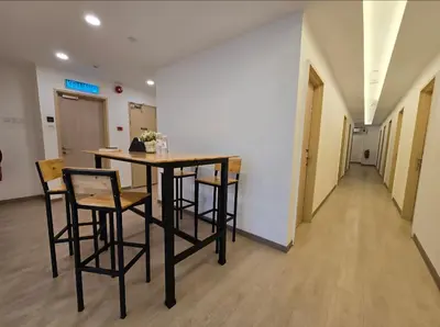 a room with a table and chairs and a hallway at The Backpackers Hut Chow Kit in Kuala Lumpur