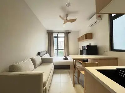 a living room with a couch and a kitchen at Arte Mont Kiara By Comfortcorner in Kuala Lumpur
