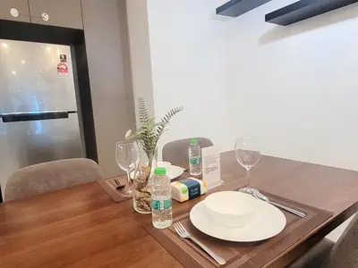 a wooden table with plates and wine glasses on it at Eaton Residence KLCC Kuala Lumpur in Kuala Lumpur