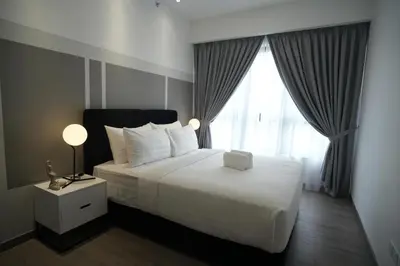 a bedroom with a large white bed with a window at Luxury Suites at Wyndham KLCC in Kuala Lumpur