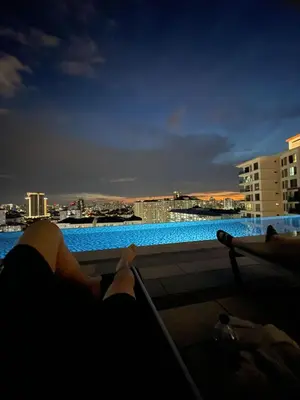 a person laying on a balcony looking out at the city at The nest apartment in Kuala Lumpur