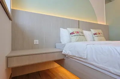 a room with a bed with white sheets and pillows at Riveria City Home Plus in Kuala Lumpur