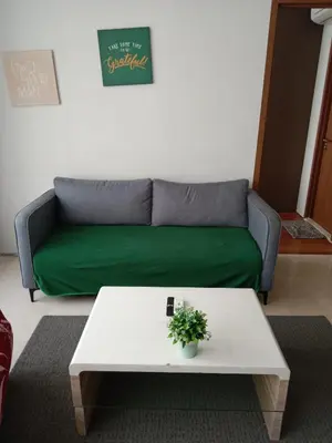 a living room with a green couch and a table at Vortex Suites KLCC by Comfy Stay in Kuala Lumpur