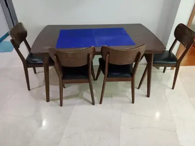 a wooden table with four chairs and a bluevisor on it at Vortex Suites KLCC by Comfy Stay in Kuala Lumpur