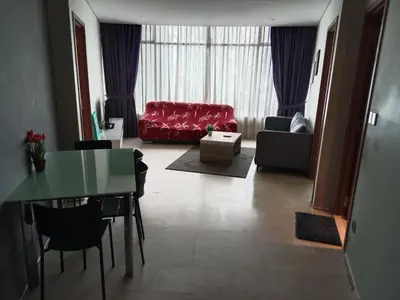 a living room with a red couch and a table at Vortex Suites KLCC by Comfy Stay in Kuala Lumpur