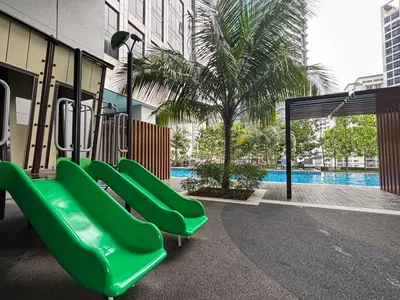a green slide in a playground with a pool at Pavilion Ceylon Hill Luxury suit Bukit Bintang by cupidhome in Kuala Lumpur