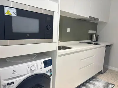 a kitchen with a washing machine and a microwave at Pavilion Ceylon Hill Luxury suit Bukit Bintang by cupidhome in Kuala Lumpur