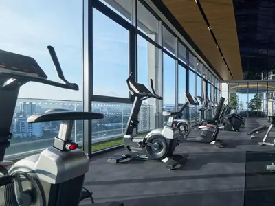 a row of exercise bikes in a gym with windows at The Atrium at Jalan Ampang by OKBnB- Modern Cozy 3 Bedroom Apartment 4 Mins to KLCC in Kuala Lumpur