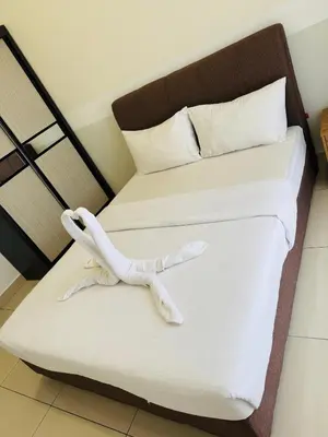 a bed with a stuffed animal sitting on it at Trion KL Residence By CozyNest in Kuala Lumpur