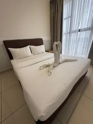 a bedroom with two beds with white sheets and a window at Trion KL Residence By CozyNest in Kuala Lumpur