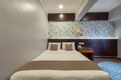 a bedroom with a bed and a desk with a phone at Hotel Grand Orchard in Kuala Lumpur