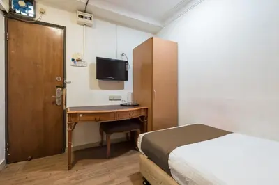 a bedroom with a bed and a desk with a bed gmaxwell gmaxwell gmaxwell at Hotel Grand Orchard in Kuala Lumpur