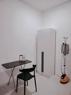 a room with a desk and a chair and a refrigerator at Netflix - City View Pano Studio with Skypool, Free parking and 5 mins to MRT in Kuala Lumpur