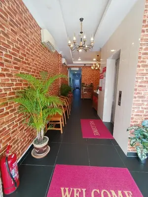 a dining room with a brick wall and pink welcome mats at J Hotel Masjid India KL in Kuala Lumpur