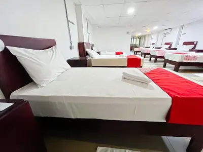 two beds in a room with red and white at J Hotel Masjid India KL in Kuala Lumpur
