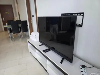 a large flat screen tv sitting on top of a cabinet at Vortex suites klcc by musab in Kuala Lumpur