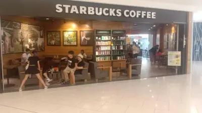 a group of people walking into a starbucks coffee shop at QUILL RESIDENCE by ASHNAS in Kuala Lumpur