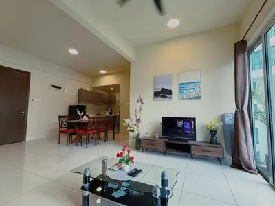 a living room with a tv and a table at Spacious Family 2BR Balcony Comfy Regalia Suites in Kuala Lumpur