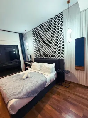 a bedroom with a large bed with a tv on the wall at Family Suites Reizz Ampang 2R2B in Kuala Lumpur