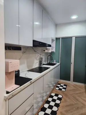 a kitchen with white cabinets and a black and white checkered floor at Yasemin Homestay in Kuala Lumpur