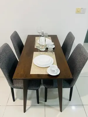 a wooden table with chairs and plates and wine glasses at Mercu summer suits 1BR luxury couple room free Netflix 5mint WD KLCC by Top R in Kuala Lumpur