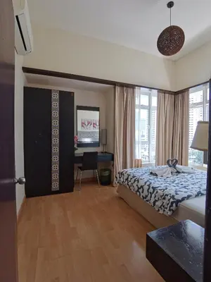 a bedroom with a bed and a desk with a computer at Seri Bukit Ceylon in Kuala Lumpur