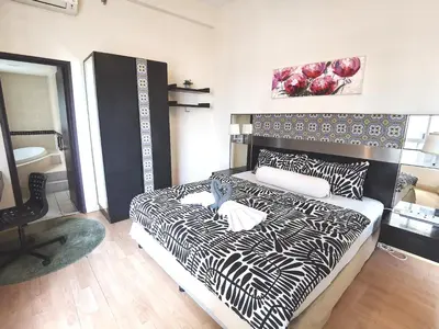 a bedroom with a black and white bed and a chair at Seri Bukit Ceylon in Kuala Lumpur