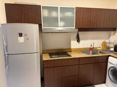 a kitchen with a white refrigerator and wooden cabinets at Seri Bukit Ceylon in Kuala Lumpur