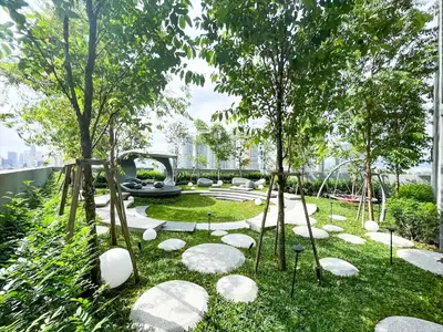 a garden with rocks and trees and a fountain at Scarletz Suite KLCC 2 in Kuala Lumpur
