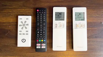 a group of four remote controls sitting on a table at Scarletz Suite KLCC 2 in Kuala Lumpur