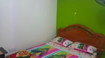 a bed with a wooden head board in a room at Zam Zam Homestay in Kuala Lumpur