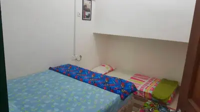 a small bedroom with a bed with a blue canopy at Zam Zam Homestay in Kuala Lumpur