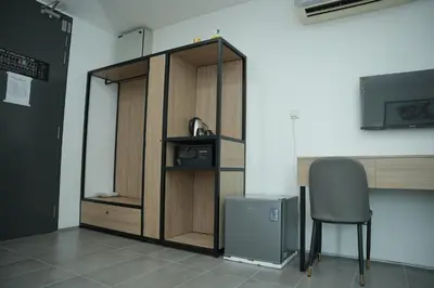a wooden cabinet with a chair in a room at Arena Suites Kuala Lumpur in Kuala Lumpur