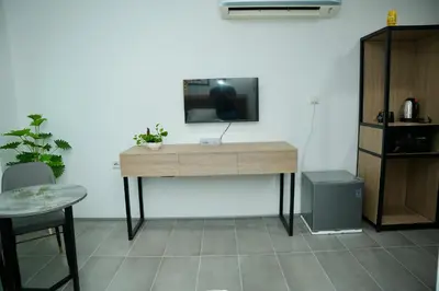 a wooden desk with a tv on a wall at Arena Suites Kuala Lumpur in Kuala Lumpur