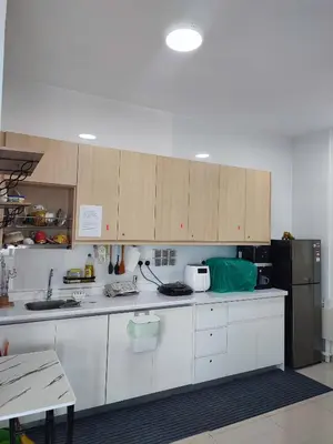 a kitchen with white cabinets and a black refrigerator at Comfy Room in High Floor! in Kuala Lumpur