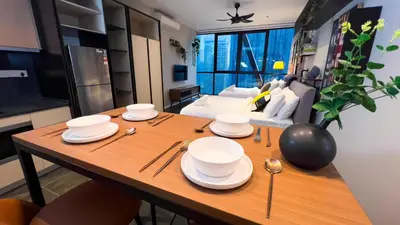 a table with plates and spoons on it in a living room at Scarletz Suite KLCC By Light House 4 in Kuala Lumpur